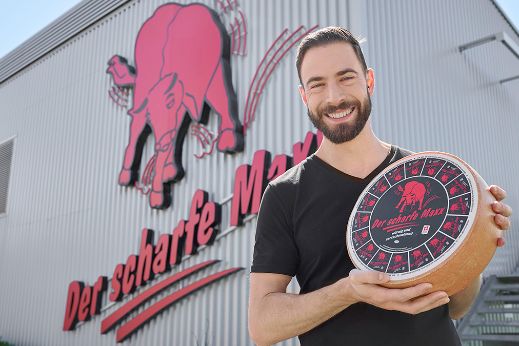 Mister Maxx 2025 mit einem Käselaib Der scharfe Maxx in der Hand.